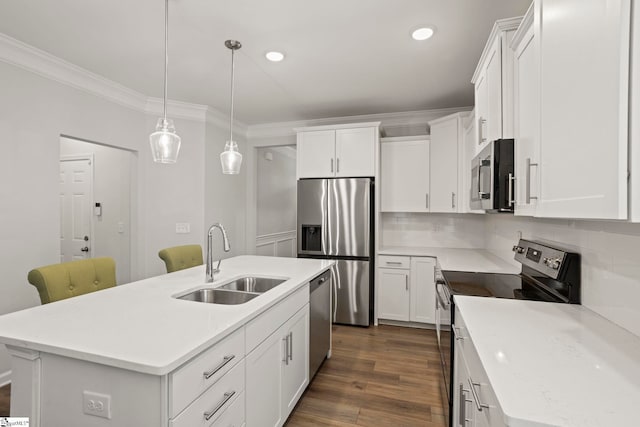 kitchen with appliances with stainless steel finishes, an island with sink, a sink, and white cabinets