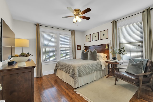 bedroom with dark wood-style floors, ceiling fan, and baseboards