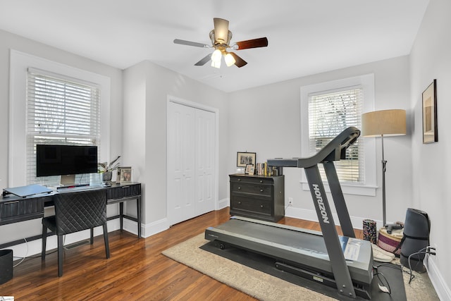 workout area with ceiling fan, dark wood-style flooring, and baseboards