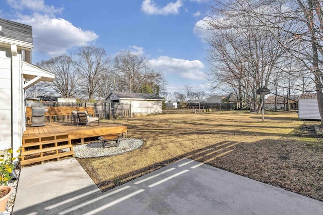 view of yard with a deck, a shed, an outdoor structure, and a fenced backyard