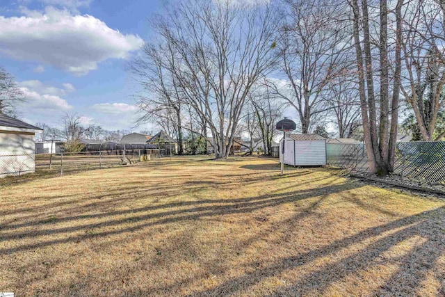 view of yard with a shed, a fenced backyard, and an outdoor structure