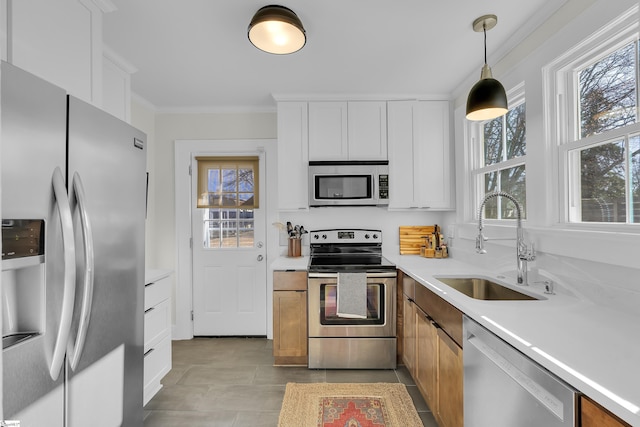 kitchen with white cabinets, pendant lighting, stainless steel appliances, and light countertops