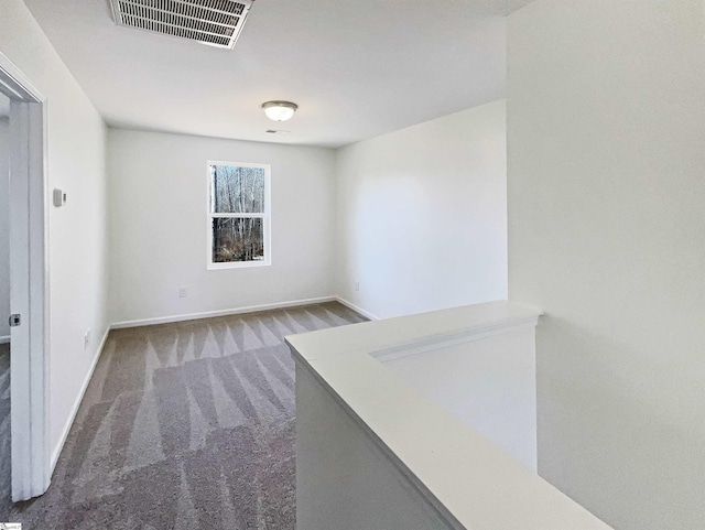 carpeted empty room featuring visible vents and baseboards