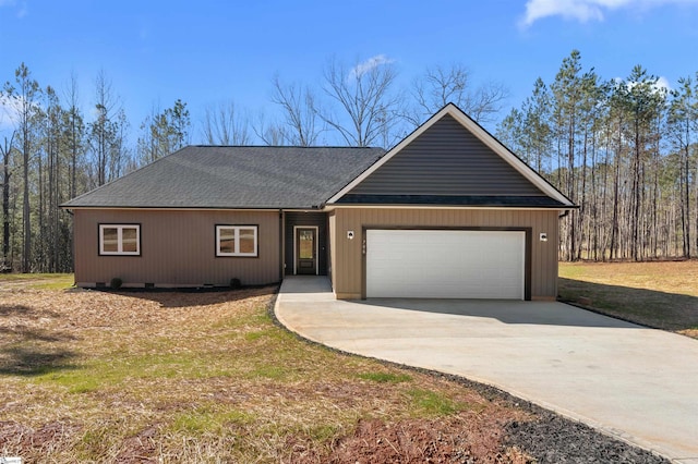 view of front of property featuring concrete driveway, a shingled roof, and an attached garage