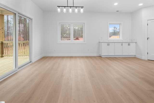 unfurnished dining area with recessed lighting, visible vents, light wood-style flooring, and baseboards