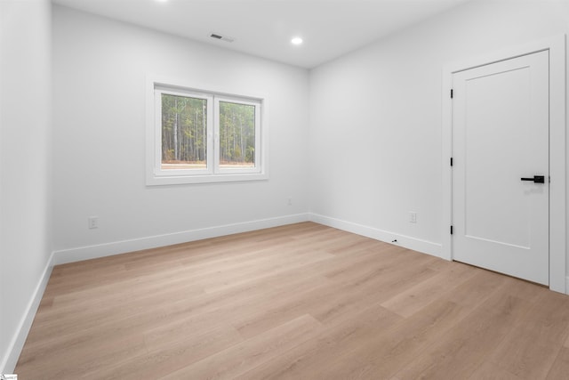 empty room with recessed lighting, baseboards, visible vents, and light wood finished floors