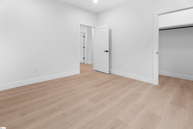 unfurnished bedroom with recessed lighting, light wood-type flooring, and baseboards