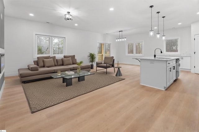 living area with light wood-style flooring, baseboards, and recessed lighting