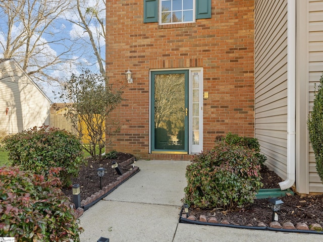 entrance to property featuring brick siding