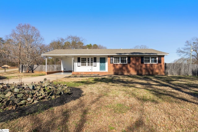 ranch-style home featuring brick siding, fence, a carport, and concrete driveway