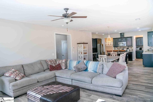 living area with ceiling fan, wood finished floors, and recessed lighting