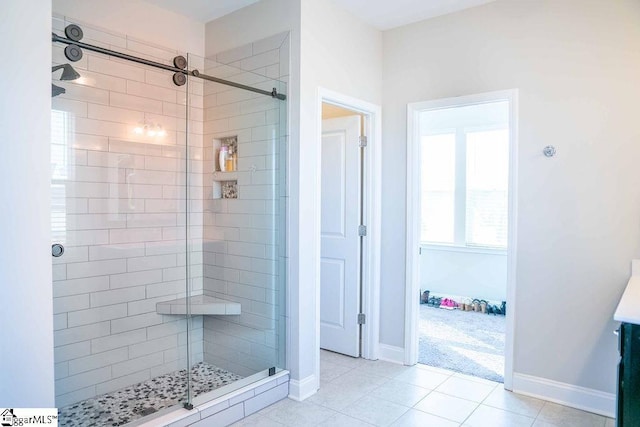 full bathroom with a shower stall, baseboards, and tile patterned floors