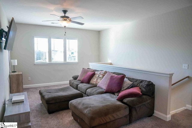 living room featuring carpet, baseboards, and a ceiling fan