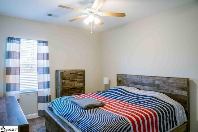 bedroom featuring visible vents, dark carpet, and a ceiling fan