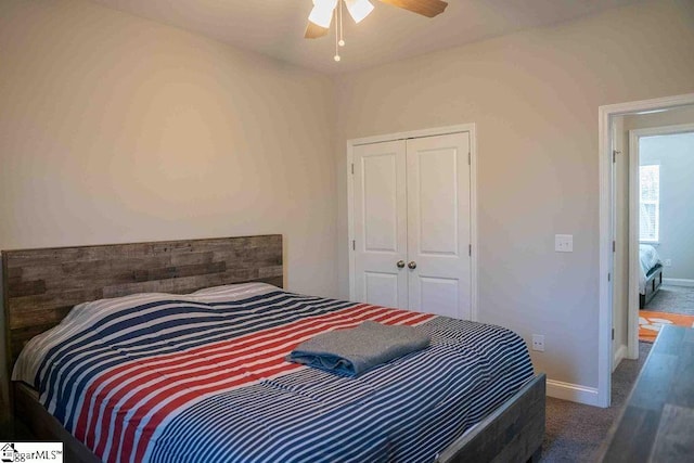 bedroom with ceiling fan, baseboards, dark colored carpet, and a closet