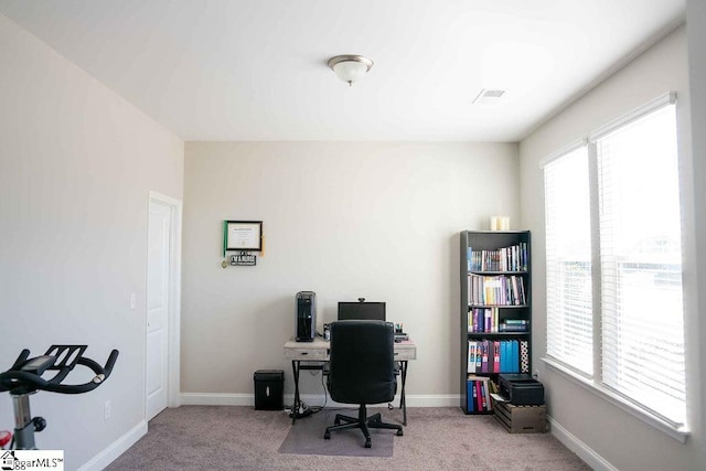 office space with baseboards, visible vents, and light colored carpet