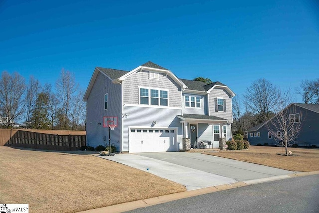 view of front facade featuring driveway, a garage, fence, and a front yard