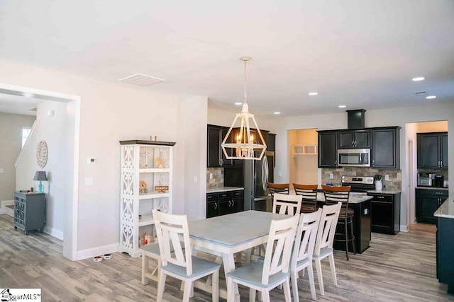 dining room featuring recessed lighting, light wood-type flooring, and baseboards