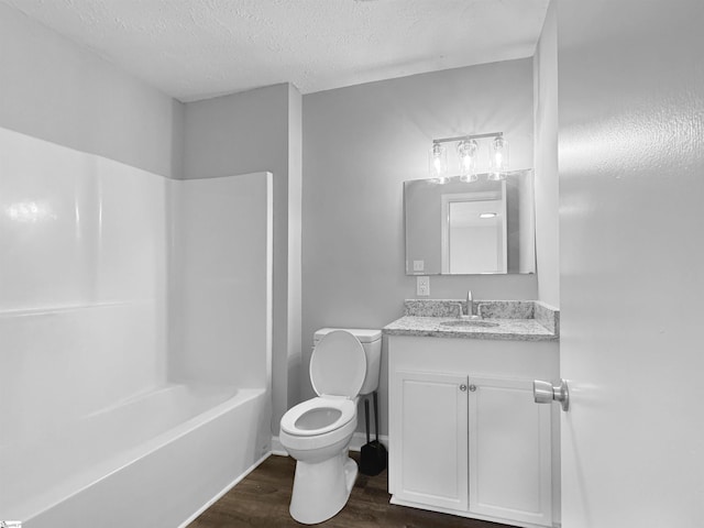 bathroom featuring bathtub / shower combination, toilet, a textured ceiling, vanity, and wood finished floors