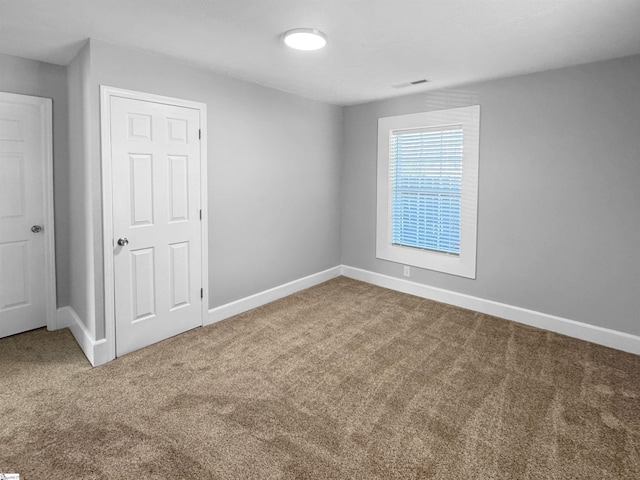 carpeted empty room with baseboards and visible vents