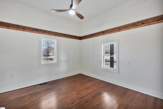 empty room with baseboards, ornamental molding, a wealth of natural light, and wood finished floors