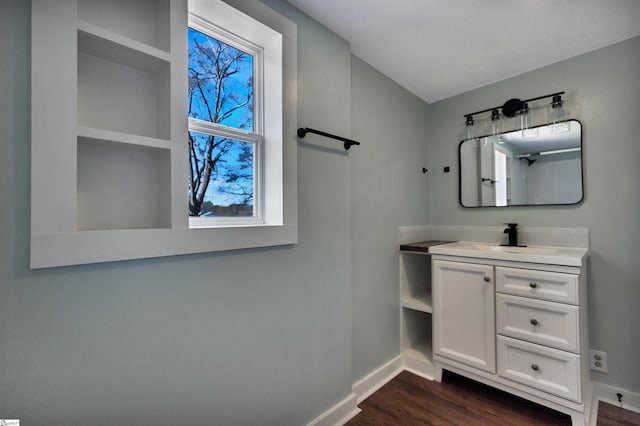 bathroom featuring baseboards, wood finished floors, and vanity