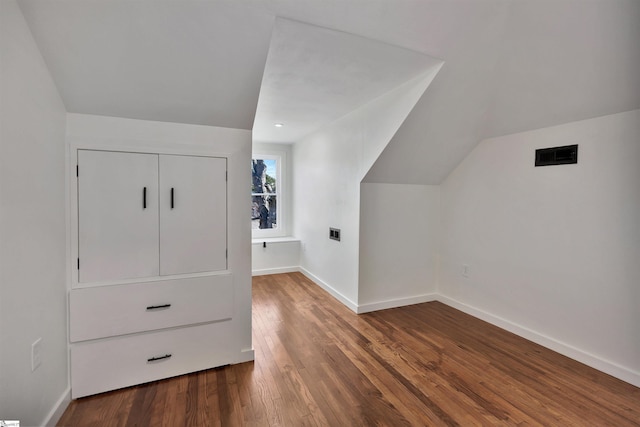 bonus room featuring visible vents, baseboards, vaulted ceiling, and wood finished floors