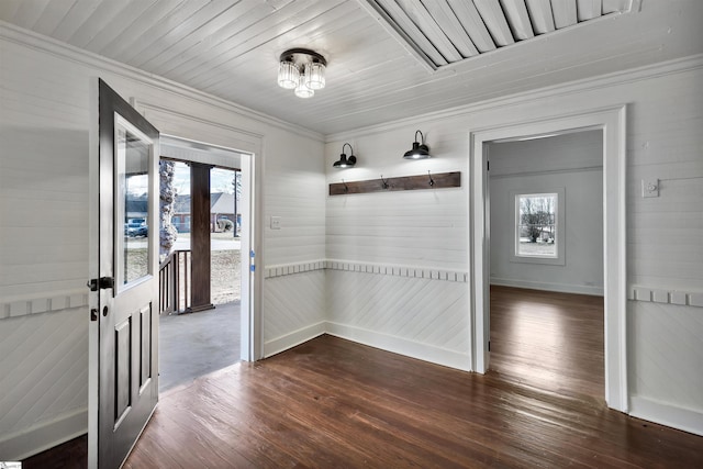 unfurnished dining area featuring dark wood-style floors, wooden ceiling, crown molding, and baseboards