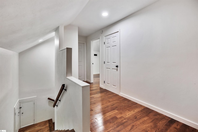 hall with dark wood-type flooring, recessed lighting, an upstairs landing, and baseboards