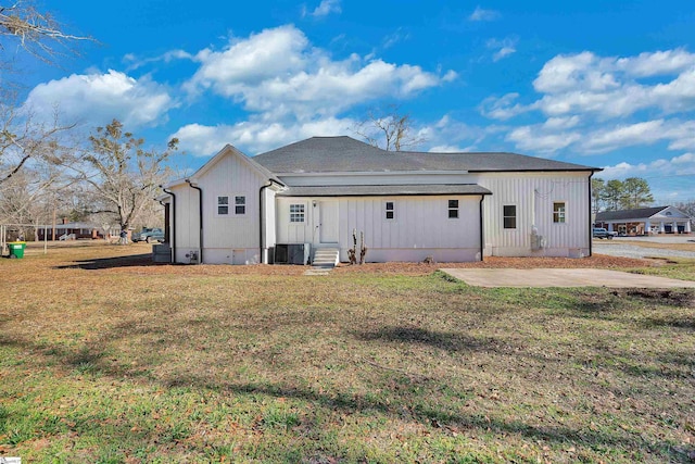 back of house featuring entry steps, a patio, a lawn, and central air condition unit