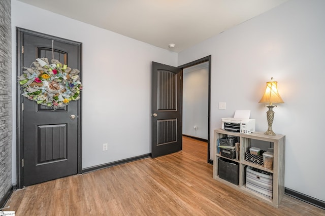 entryway featuring baseboards and wood finished floors