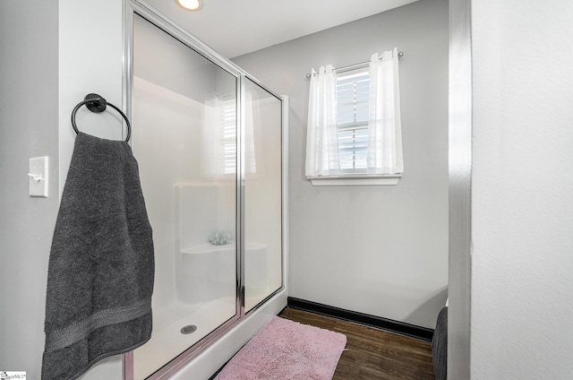 bathroom featuring a shower stall and wood finished floors