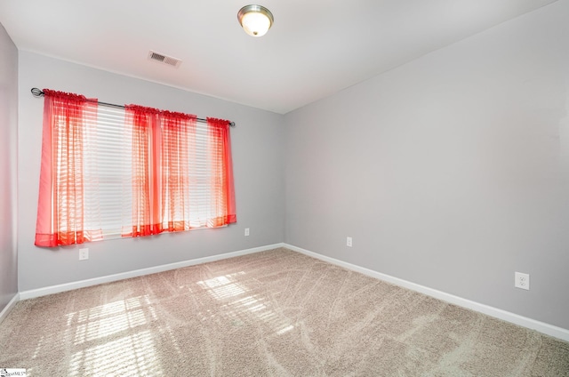 carpeted empty room featuring visible vents and baseboards