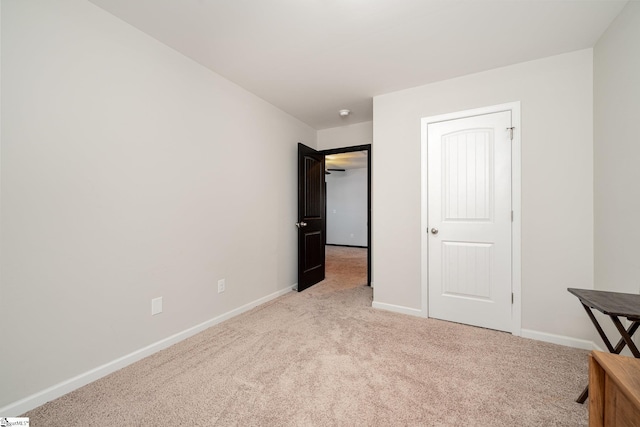 unfurnished bedroom with light carpet and baseboards