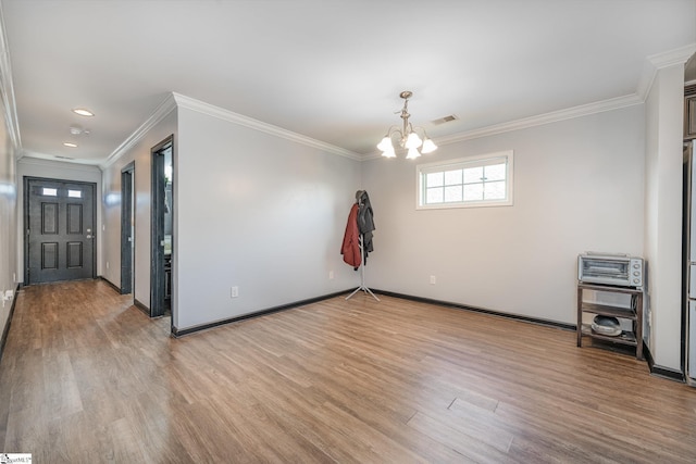 empty room with a notable chandelier, visible vents, baseboards, light wood-type flooring, and crown molding