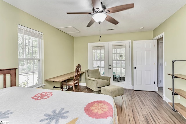 bedroom with visible vents, access to exterior, a textured ceiling, french doors, and light wood-type flooring