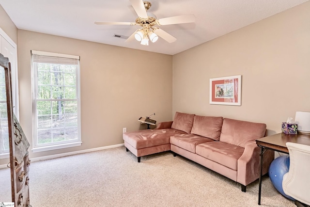 living area with ceiling fan, visible vents, baseboards, and light colored carpet