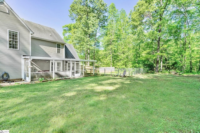 view of yard featuring a sunroom and a fenced backyard