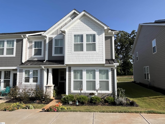 view of front of property with metal roof, a standing seam roof, and a front yard