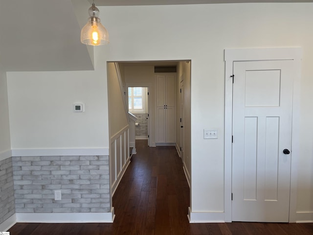 hall featuring stairs, dark wood-style flooring, and baseboards