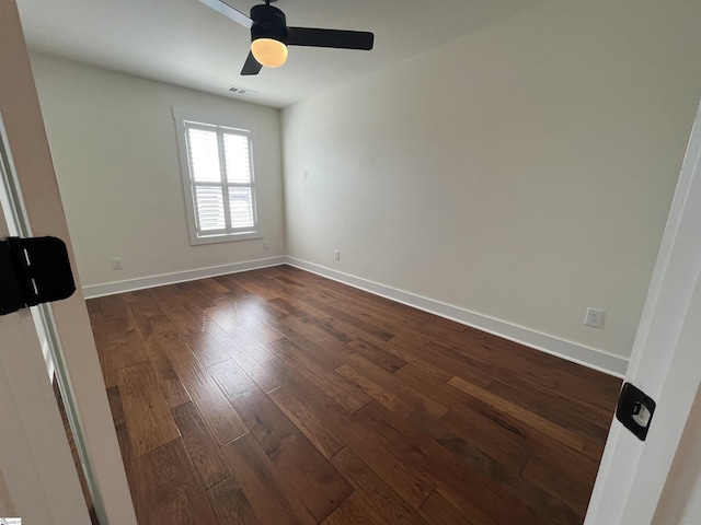 spare room with a ceiling fan, baseboards, visible vents, and dark wood-type flooring