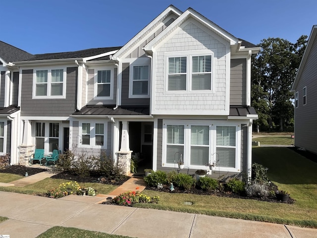 view of front of property featuring a standing seam roof, metal roof, and a front lawn