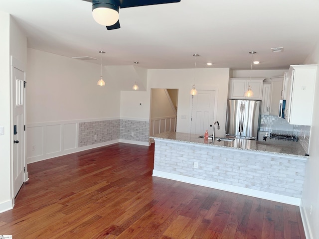 kitchen with a sink, white cabinetry, appliances with stainless steel finishes, and light stone counters