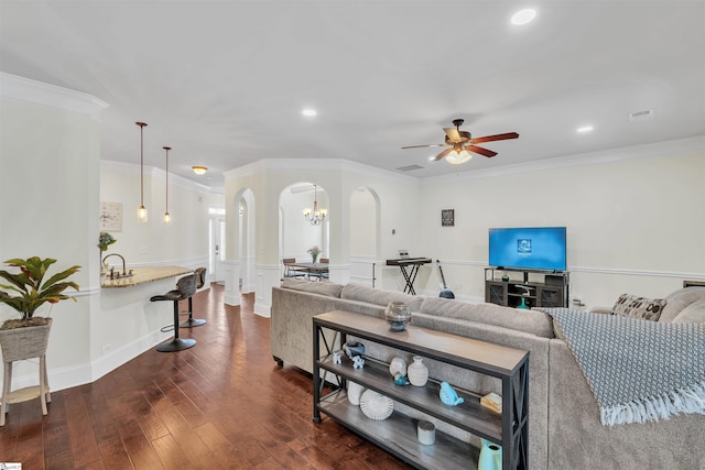 living room with arched walkways, ceiling fan, visible vents, ornamental molding, and dark wood-style floors