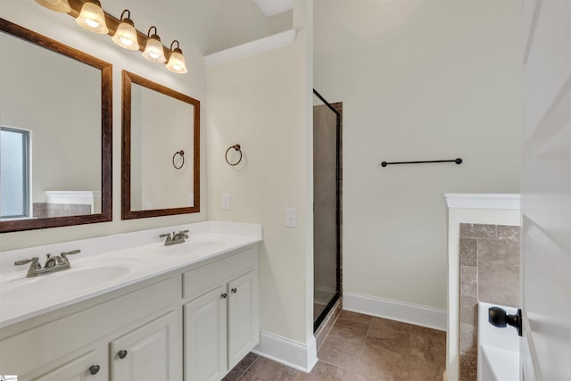 bathroom featuring double vanity, a stall shower, a sink, and baseboards