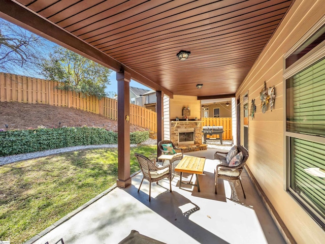 view of patio with a fenced backyard and an outdoor fireplace