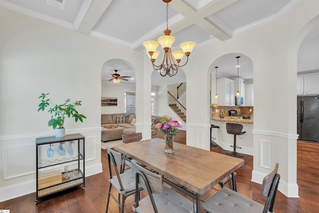 dining room with arched walkways, dark wood-style flooring, stairs, wainscoting, and beam ceiling