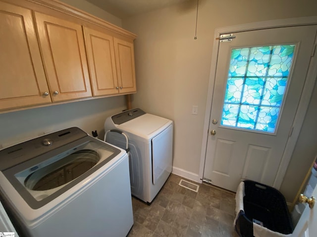 clothes washing area with cabinet space, baseboards, visible vents, and washing machine and clothes dryer