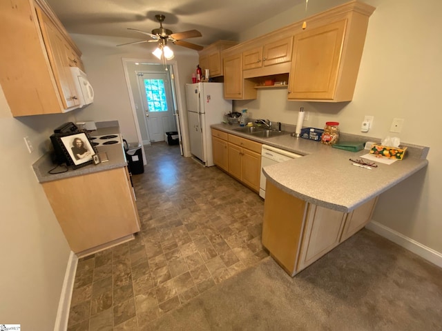 kitchen with white appliances, light brown cabinets, baseboards, and a sink