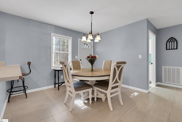 dining room with baseboards, visible vents, and a notable chandelier